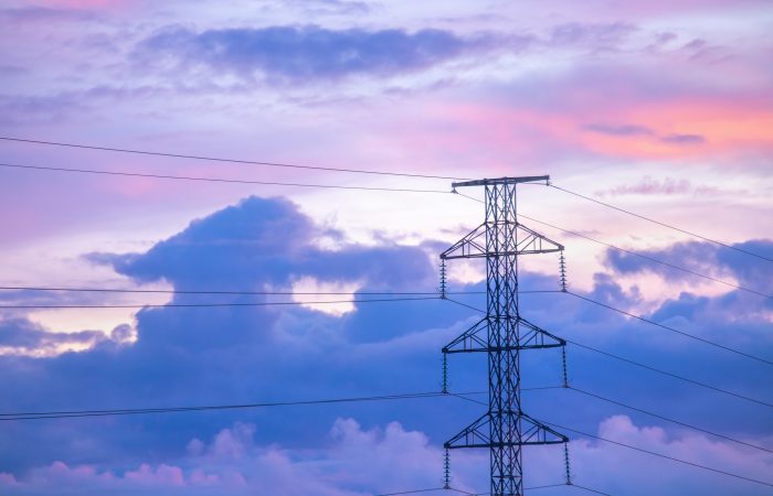 Sunrise clouds floating behind an electricity pylon, Western Finland, Northern Europe