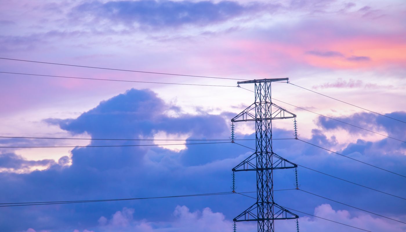 Sunrise clouds floating behind an electricity pylon, Western Finland, Northern Europe