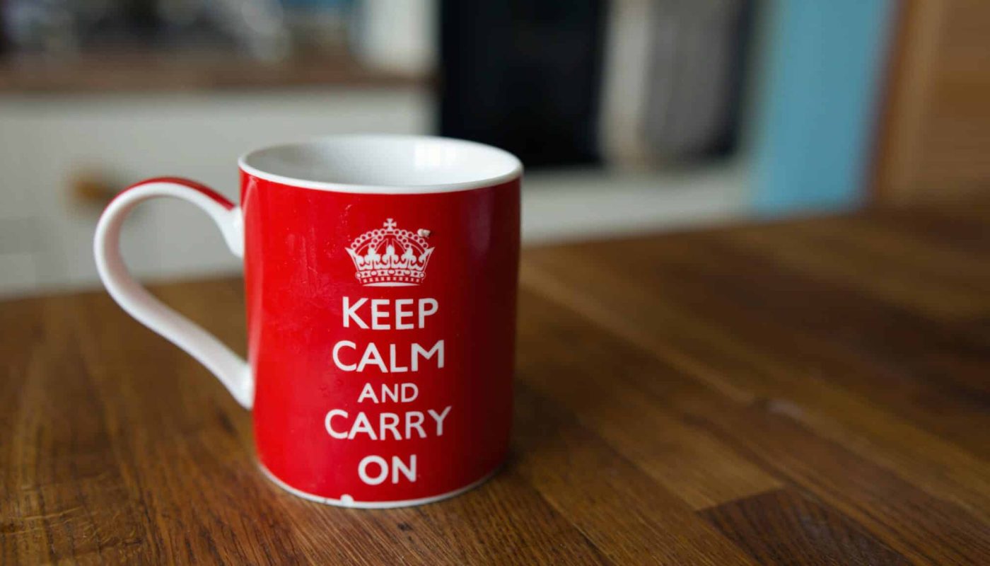 a red and white coffee cup sitting on top of a wooden table